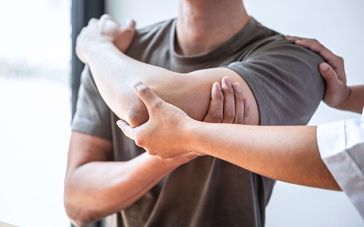 Female Physiotherapist Working Examining Treating Injured Arm Of