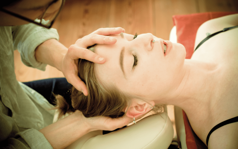 Physical therapist performing gentle cranial and neck manual therapy during post-concussion rehabilitation