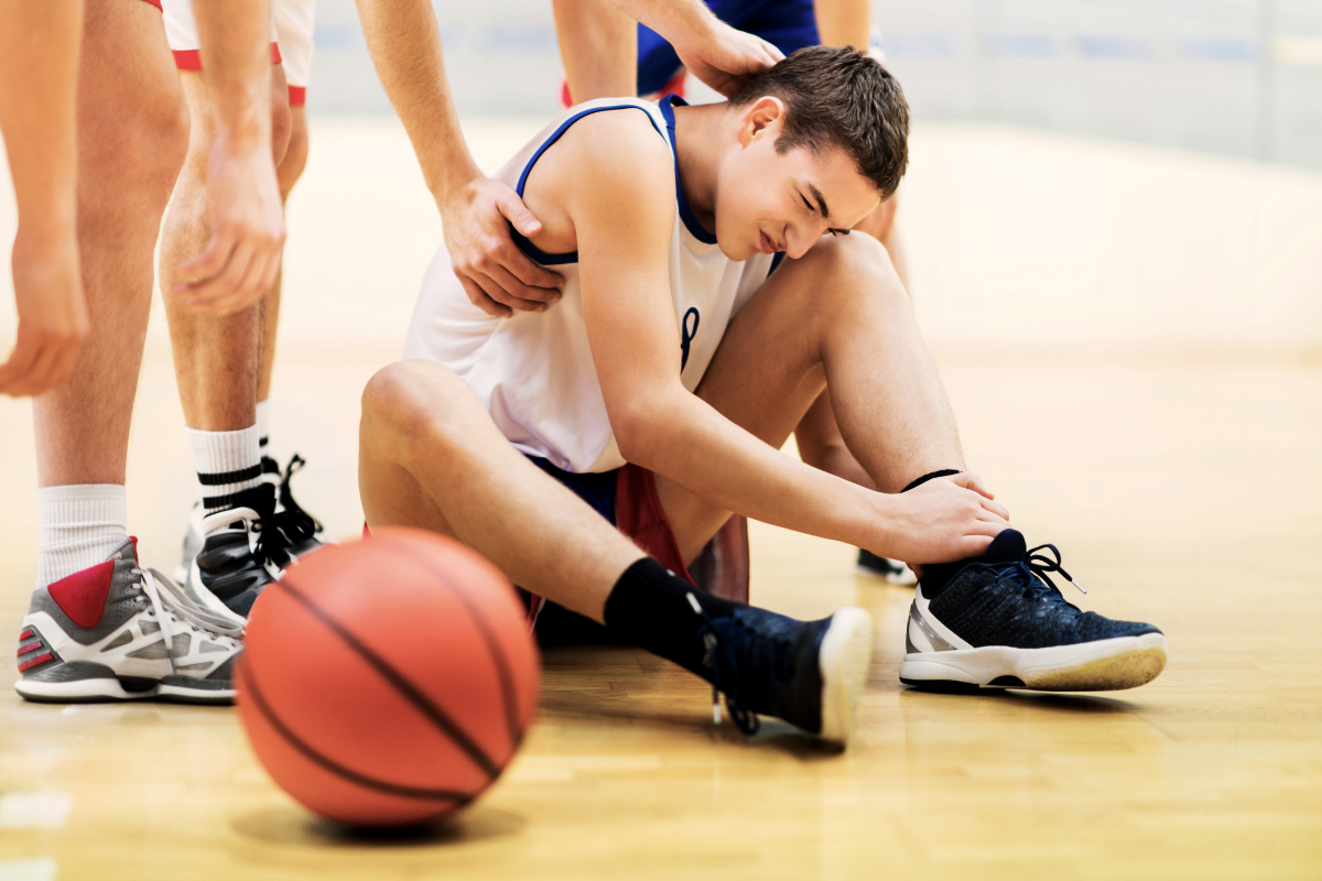 Teen basketball player with sports injury receiving support during game – sports injury physical therapy in Mount Prospect