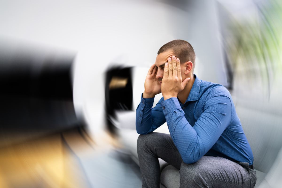 Man experiencing recurrent dizziness and vertigo while sitting on a couch